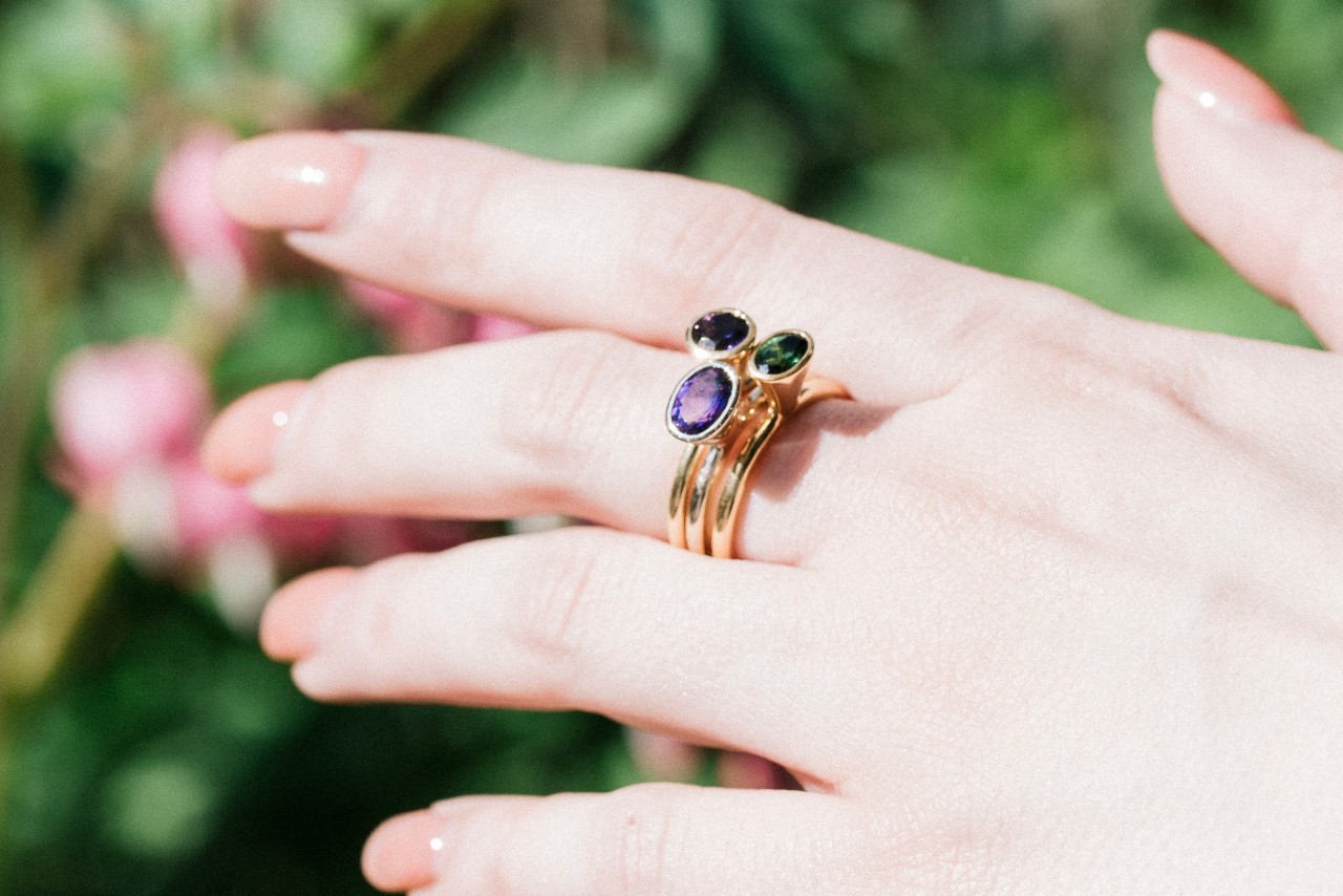 A woman’s hands wearing ring with gemstone in the middle finger