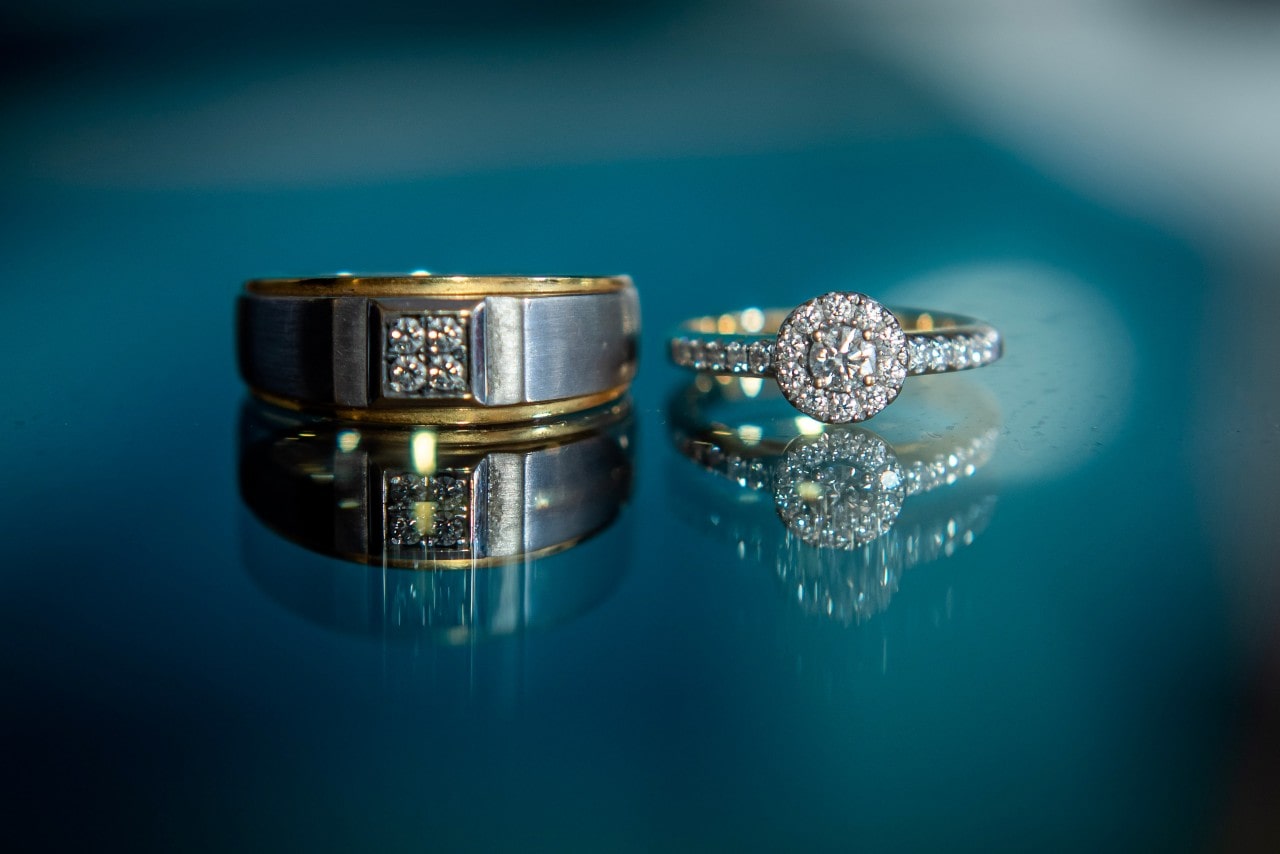 A mixed metal wedding band and a two-tone engagement ring sit side-by-side.