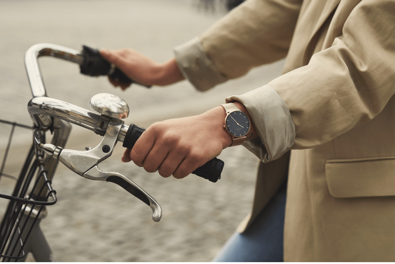 Close up of hands holding bike handlebars with a watch on the left wrist