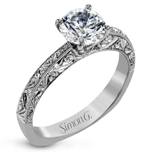A solitaire engagement ring with vintage scroll details etched in the shank.
