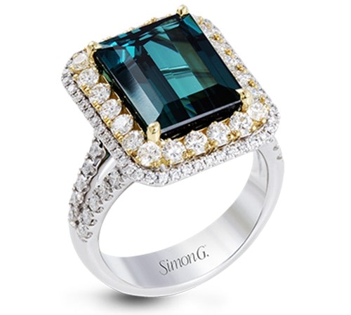 A green emerald ring with a diamond halo made by Simon G.
