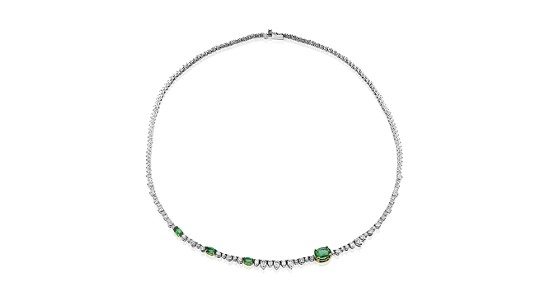 A diamond and emerald tennis necklace with stones of various sizes