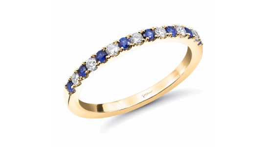 A yellow gold stacking ring set halfway around with sapphires and diamonds