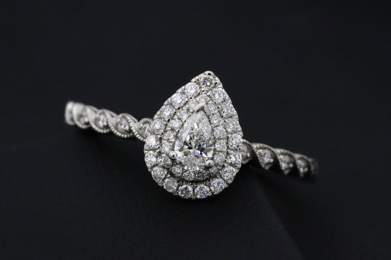 A pear-shaped diamond engagement ring with vintage-inspired shank details.