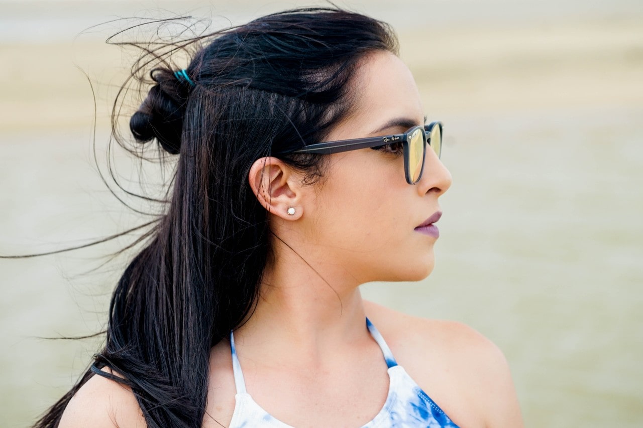 A woman wearing sunglasses and stud earrings takes in the view.