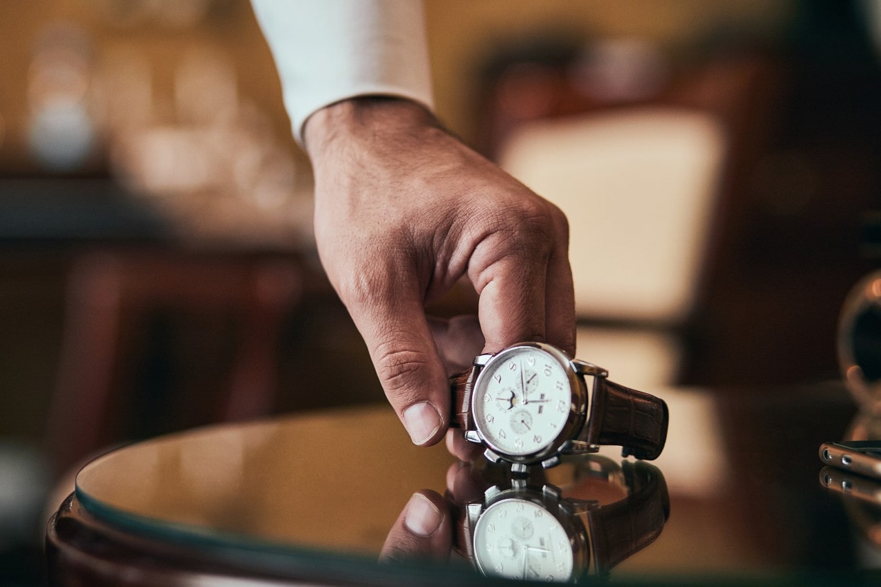 Hand picking a watch up off of a table